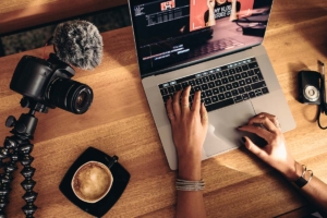 Someone working on a laptop beside a cup of coffee