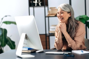 Woman with gray hair having a personalized customer experience on her computer thanks to help from AI