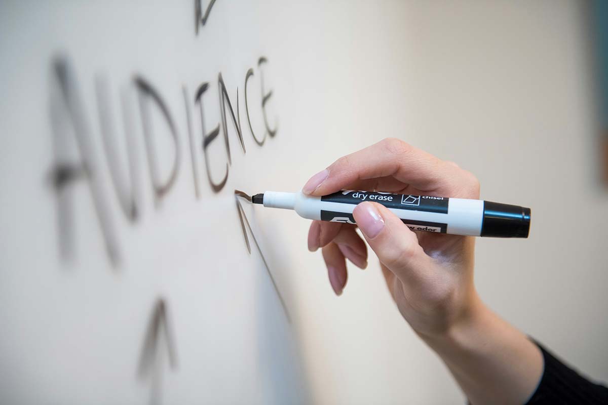 White board marker writing "AUDIENCE" for someone thinking about email audience segments