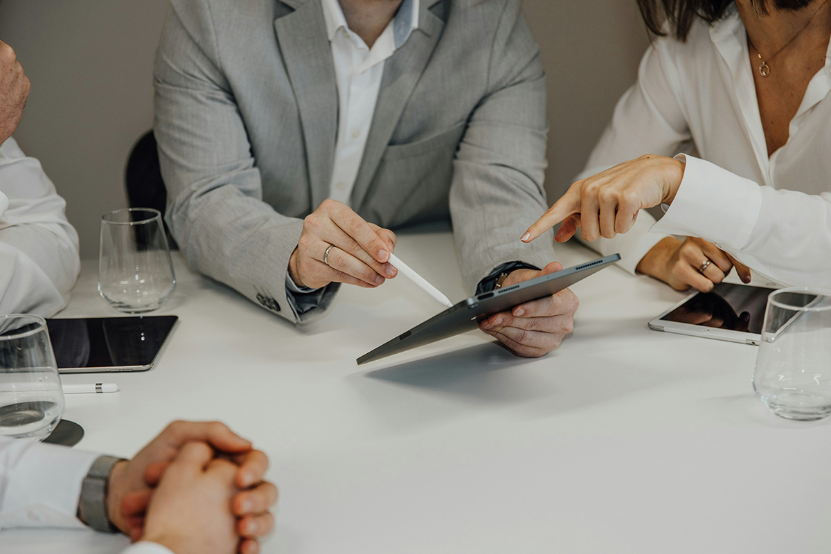 An outsourced marketing team working together on a tablet