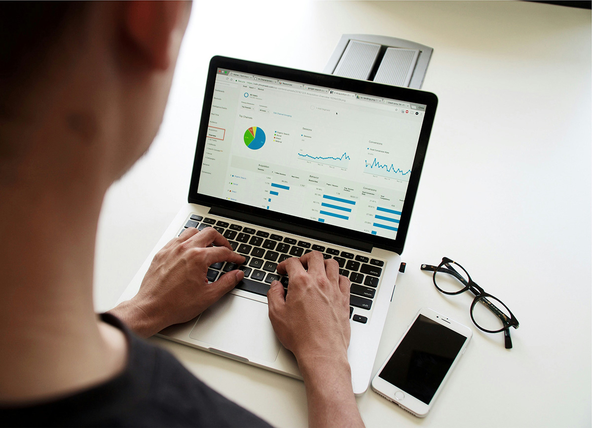A woman on a laptop with Google Analytics looking at the various metrics a business' website is measuring.